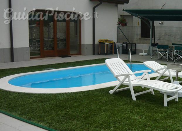 Piscina con zona verde sintetica