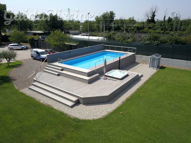 Piscina fuori terra rivestita con Jacuzzi idromassaggio incassata nel solarium .