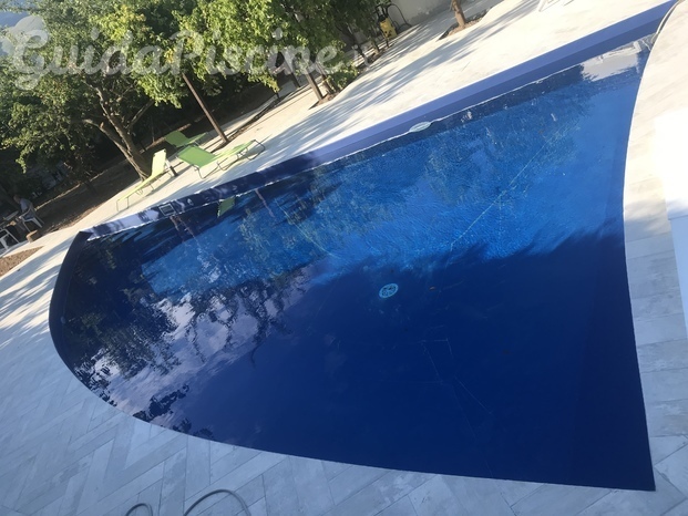 Piscina forma libera skimmer in C.A. Con rivestimento blu marine 