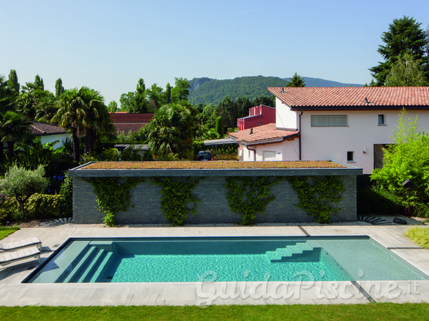 Piscina in vetroresina con Wetlounge e copertura a tapparella. Scala lineare. 