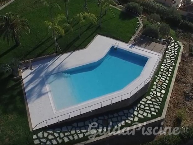 Piscina a sfioro con rivestimento in gres porcellanato e griglia ceramica invisibile