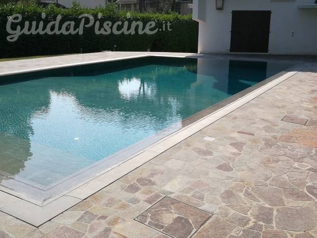 Piscina a sfioro con rivestimento e bordo in gres porcellanato 